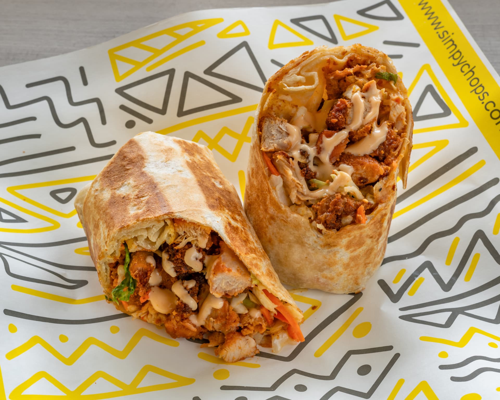Two SimplyChops suya wraps in branded yellow wrapping paper